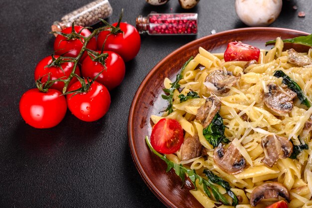 Pasta con funghi, formaggio, spinaci, rukkola e pomodorini. Piatto italiano, cultura mediterranea