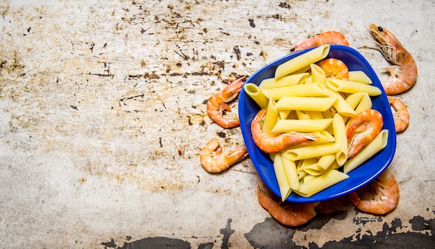 Pasta con gamberetti in un piatto. Su un tavolo rustico. Spazio libero per il testo. Vista dall'alto