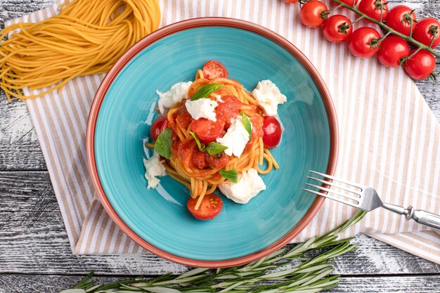 Pasta con la pasta dei pomodori su una vista superiore del fondo di legno bianco