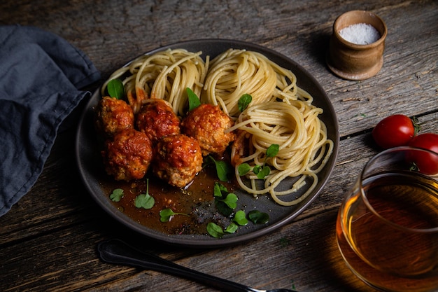 Pasta con polpette e salsa in un piatto su un tavolo di legno