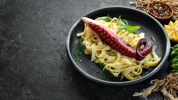 Pasta con polpo su un piatto di pietra Vista dall'alto Spazio libero per la copia