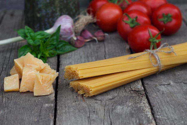 Pasta con pomodori aglio parmigiano e basilico sulla vecchia tavola di legno