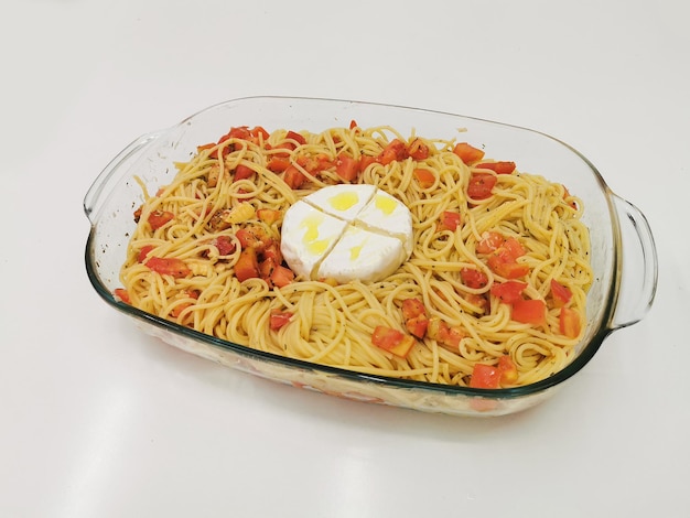 Pasta con pomodori e formaggio camembert su sfondo bianco Spaghetti