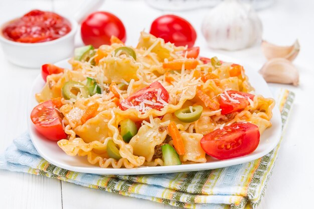 Pasta con pomodori e parmigiano su un piatto bianco