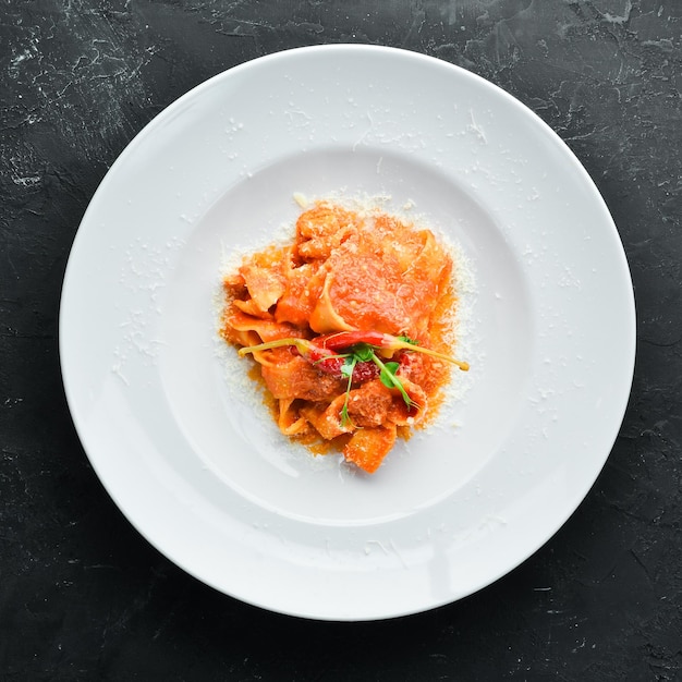 Pasta con pomodori e peperoncino in un piatto. Vista dall'alto. Spazio libero per il tuo testo.