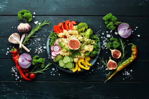 Pasta con pomodori, fichi e verdure fresche Ricetta della ciotola del Buddha Menu dei piatti Spazio per la copia gratuito Vista dall'alto