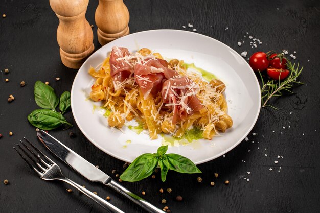 Pasta con prosciutto e formaggio parmigiano su fondo di legno