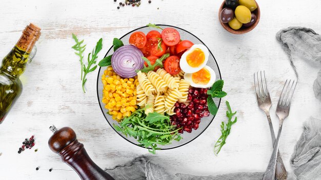 Pasta con rucola pomodoro uovo di mais in una ciotola Ciotola Buddha Vista dall'alto spazio libero per il testo