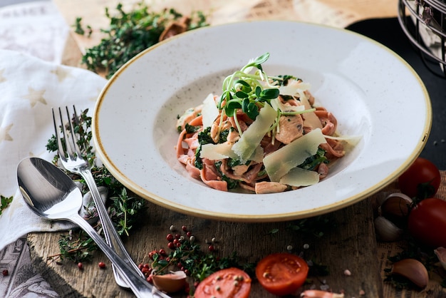 Pasta con salmone e spinaci su fondo di legno