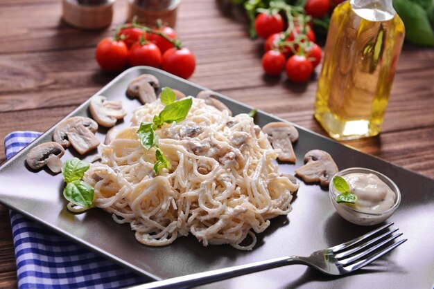 Pasta con salsa di funghi sul primo piano della tavola di legno