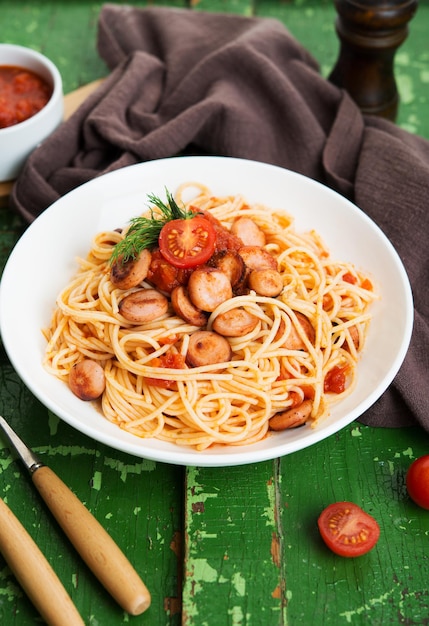 Pasta con salsicce e salsa di pomodoro su fondo rustico, fuoco selettivo