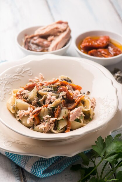 Pasta con tonno pomodori secchi e capperi a fuoco selettivo