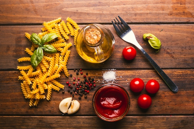 Pasta con vari ingredienti per cucinare cibo italiano, su un tavolo in legno rustico