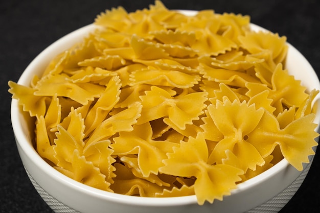 Pasta cruda Cavatappi Cellentani in un piatto isolato su sfondo scuro vista dall'alto