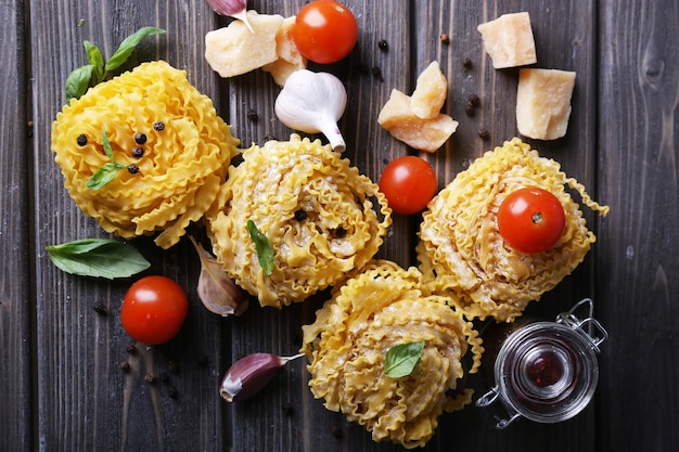 Pasta cruda con formaggio e verdure su fondo di legno