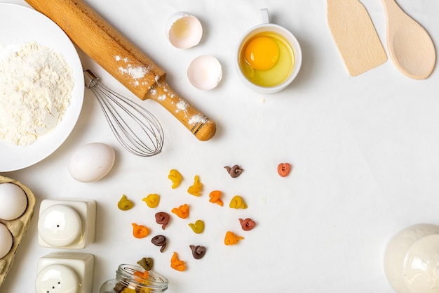 Pasta cruda con ingredienti sul tavolo bianco Vista dall'alto Diversi tipi di pasta Vari tipi di pasta Cucina italiana Spazio libero per il testo Sfondo pasta Farina e uova