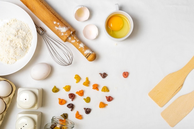 Pasta cruda con ingredienti sul tavolo bianco Vista dall'alto Diversi tipi di pasta Vari tipi di pasta Cucina italiana Spazio libero per il testo Sfondo pasta Farina e uova