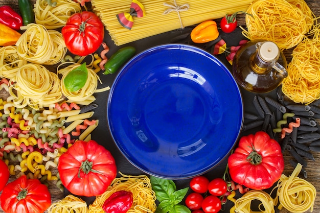 Pasta cruda con ingridients e copia spazio sul piatto blu