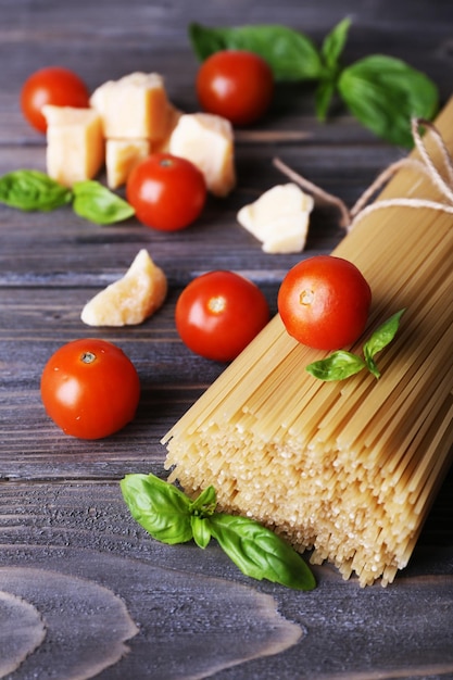 Pasta cruda con pomodori e formaggio su fondo di legno