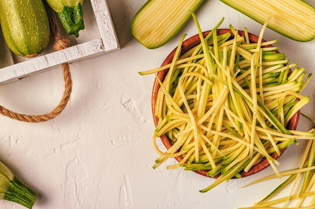 Pasta cruda dello zucchini su bianco