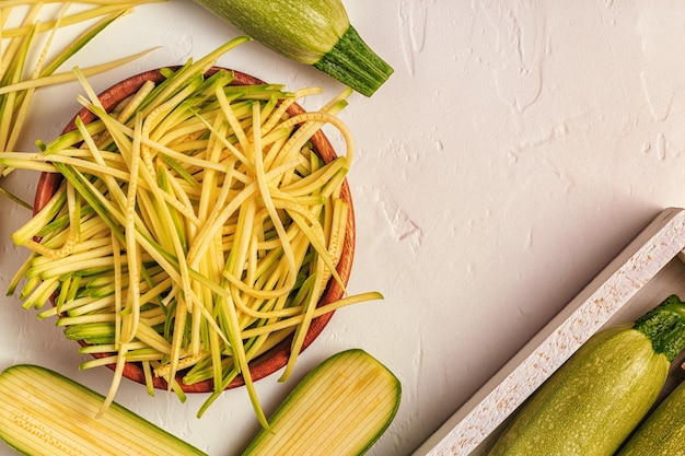 Pasta cruda dello zucchini su bianco