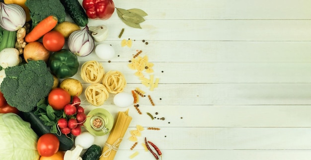 Pasta cruda di vari tipi e spezie su un tavolo di legno