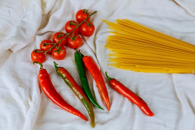 Pasta cruda e ingredienti con pomodori