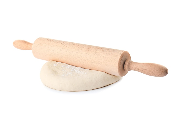 Foto pasta cruda e mattarello su sfondo bianco