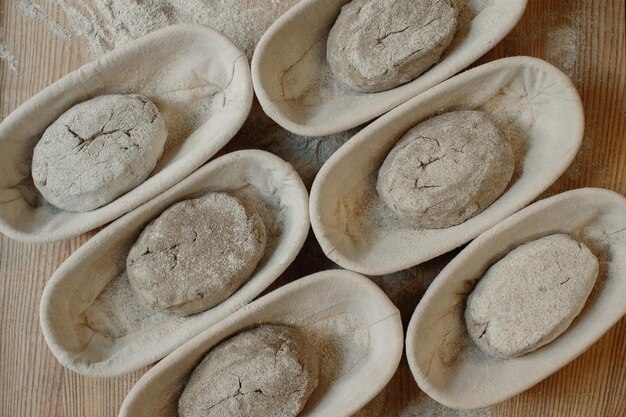 Pasta cruda fresca in stampi di legno sul tavolo prima di cuocere il pane fatto in casa