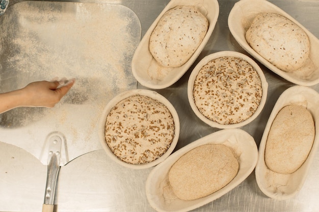 Pasta cruda fresca in stampi di legno sul tavolo prima di cuocere il pane fatto in casa