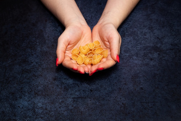 Pasta cruda sulle mani della donna