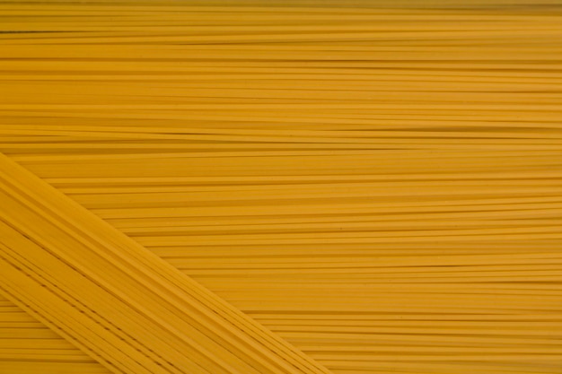 Pasta degli spaghetti Cibo della cucina italiana. Fondo giallo dell'alimento degli spaghetti lunghi