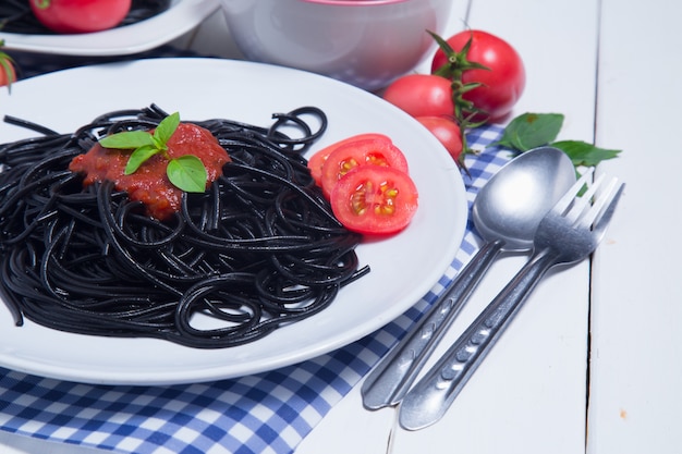 Pasta degli spaghetti con e salsa di pomodori su fondo di legno