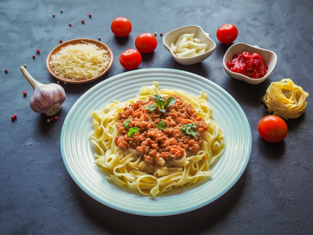 Pasta degli spaghetti con salsa besciamella su una superficie nera