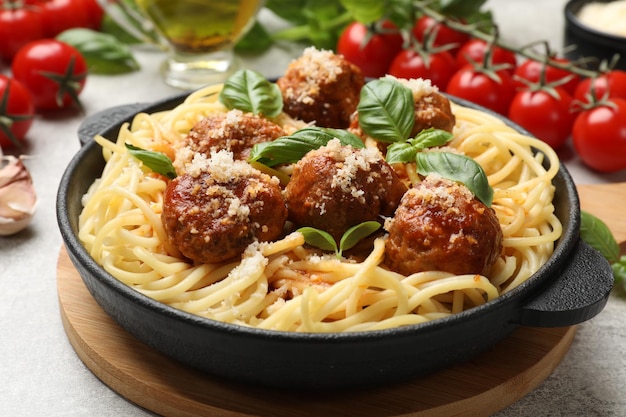 Pasta deliziosa con polpette e ingredienti su tavolo grigio chiaro in primo piano