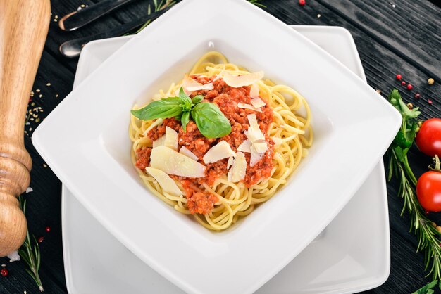 Pasta della cucina italiana con pomodori e parmigiano su sfondo di legno Vista dall'alto Copia spazio