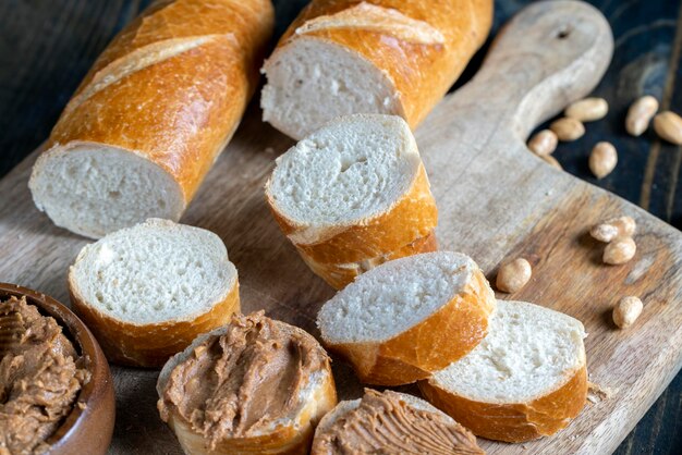 Pasta di arachidi con pezzi di arachidi e baguette bianca colazione al burro di arachidi con pezzi di noci e baguette di grano