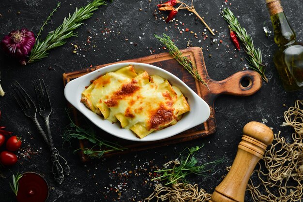 Pasta di cannelloni al forno con sugo di crema di carne formaggio Cucina italiana Vista dall'alto Spazio per la copia gratuito