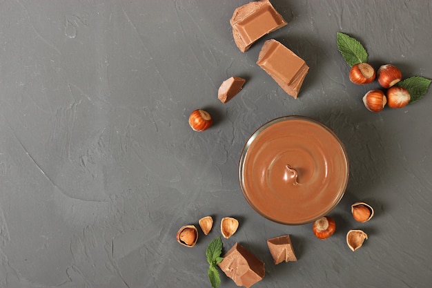 Pasta di cioccolato in un barattolo di vetro su sfondo colorato