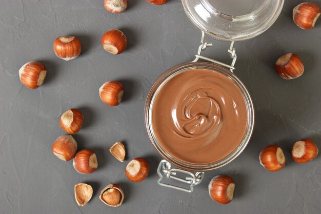 Pasta di cioccolato in un barattolo di vetro su sfondo colorato