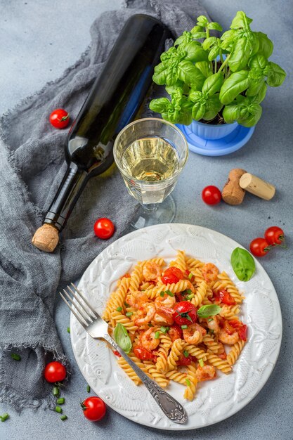 Pasta di gamberi al pomodoro e un bicchiere di vino bianco