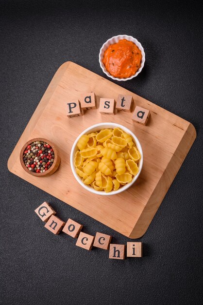 Pasta di gnocchi di grano duro grezzo con sale e spezie in un piatto di ceramica