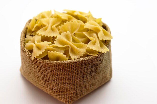 Pasta di grano duro in un sacchetto di tela su sfondo bianco Closeup pasta italiana