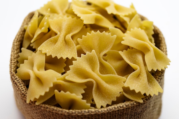 Pasta di grano duro in un sacchetto di tela su sfondo bianco Closeup pasta italiana