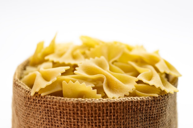Pasta di grano duro in un sacchetto di tela su sfondo bianco Closeup pasta italiana