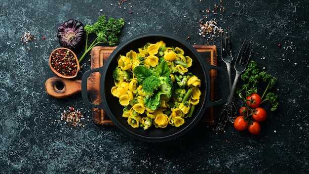 Pasta di mais con verdure. Spinaci, broccoli, pasta. Vista dall'alto. Spazio libero per il tuo testo.