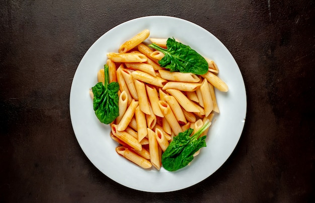 Pasta di Penney in salsa al pomodoro su fondo concreto