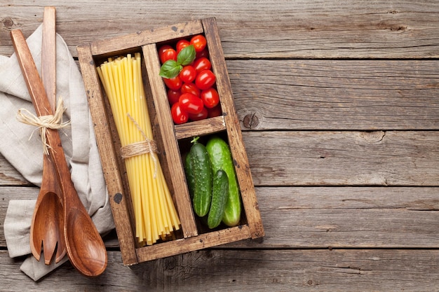 Pasta e ingredienti Pomodoro basilico cetriolo Concetto di cucina Vista dall'alto con spazio per il testo