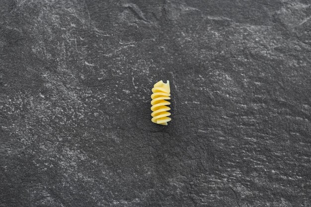 Pasta eliche cruda isolata su sfondo scuro con tracciato di ritaglio