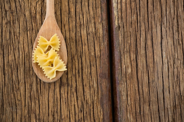 Pasta Farfalle servita in cucchiaio su una superficie di legno